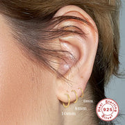 Sterling Silver Huggie Earrings in Gold — Thin 18K Gold Plated Huggies on model